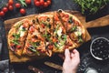 Flatbread pizza garnished with fresh arugula on wooden pizza board, top view Royalty Free Stock Photo