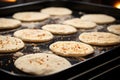 flatbread rounds being dropped onto a baking tray Royalty Free Stock Photo