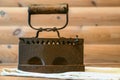 Flatiron view from the side on the background of wooden wall and wooden table, ancient belongings of the resident of the Russian v Royalty Free Stock Photo