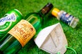 Flatlay of alcohol liquor bottles on grass with a mask and sanitizer showing the home delivery and purchase of alcohol