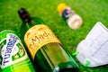 Flatlay of alcohol liquor bottles on grass with a mask and sanitizer showing the home delivery and purchase of alcohol
