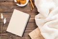 Flatlay autumn composition. Women fashion white sweater, paper notepad with empty page, cinnamon, cookies on wooden background.