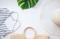 Flatlay bikini, hat, sunglasses, starfish, green leaf of plum on white background