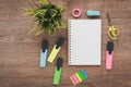 flatlay on a wooden background, colorful pastel markers, scissors, stapler, scotch tape, stickers, scissors, stationery,