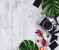 Flatlay with camera, blank photo, coins, sunglasses, leaves on t