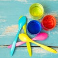Flatlay, colorful egg spoons and egg dyes on blue wooden table