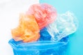 Flatlay colorful plastic bags in a garbage bag on a blue and white background. Sorting of polyethylene waste. Save the