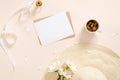 Flatlay composition with blank paper card mockup, envelope straw hat, daisy flowers, tea cup, ribbon on pastel pink background. Royalty Free Stock Photo