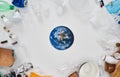 Flatlay composition with different waste, garbage types and paper model of Earth in the center over white background Royalty Free Stock Photo