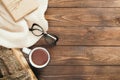 Flatlay composition with red scarf, cup of tea, firewood, book on wooden desk table. Hygge style, cozy autumn or winter holiday Royalty Free Stock Photo