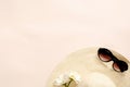 Flatlay composition with straw hat, daisy flowers and sunglasses on pastel pink background. Flat lay, top view, copy space. Summer