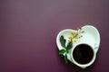 Flatlay A cup of coffee and on a saucer in the shape of a heart lies a twig with small yellow flowers and leaves Royalty Free Stock Photo