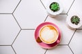 Flatlay with a cup of soy latte in a pink mug on ceramic table