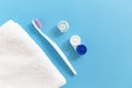 Flatlay of dental care tools and lenses: toothbrush and paste, container and towel on a blue background. Royalty Free Stock Photo