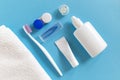 Flatlay of dental care tools and lenses: toothbrush and paste, container and towel on a blue background. Royalty Free Stock Photo