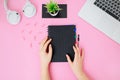 Flatlay with female office desk on a pink background.