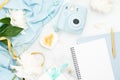 Flatlay of feminine home office desk. table. Fashion blogger workspace with pastel blue instant camera, peony flowers and