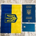 Flatlay, the flag of Ukraine with the coat of arms, a bank card and a passport of a citizen of Ukraine on a light gray