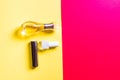 flatlay of glass bottle of perfume, nail polish and lip stick  on yellow and red background. Beauty product, cosmetic concept. Royalty Free Stock Photo