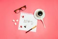 Flatlay with glasses, pen, clips, cup of coffee and white page with handlettering `Hello Monday`.