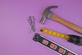 Flatlay of Hammer, Nails, Tape Measure and Level Isolated on a Lavender Purple Background Royalty Free Stock Photo