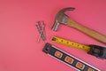 Flatlay of Hammer, Nails, Tape Measure and Level Isolated on a Pink Background Royalty Free Stock Photo