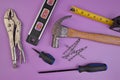 Flatlay of Hand Tools Purple Background Including Hammer, Nails, Tape Measure, Level, Screwdrivers Royalty Free Stock Photo