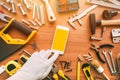 Flatlay handyman smartphone app, repairman holding mobile phone in hand