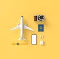 Flatlay with hat with sun glasses, toy plane, slippers, hat, suntan cream, phone and camera on yellow minimal style background.