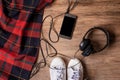 Flatlay of hipster sneaker shoes ,mobile phone with black screen and headphone