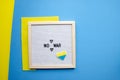 Flatlay horizontal composition NO WAR with framed letter board and embroidered patriotic ukrainian heart and blank blue background