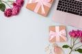 Flatlay with laptop, rose flowers, gift boxes with tied bows