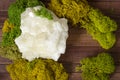 Flatlay with a large piece of white quartz among moss on a wooden background.