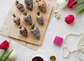 Flatlay in light colors: coffee, chocolate-covered strawberries, flowers. Royalty Free Stock Photo