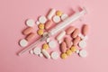 Flatlay, many different pills and a syringe on a pink background Royalty Free Stock Photo