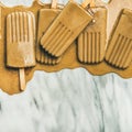 Flatlay of melting coffee latte popsicles, square crop