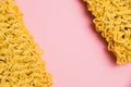 Flatlay, paper background with copy space. Two large servings of instant noodles on a pink background.