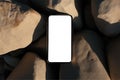 Flatlay phone on sand-colored stones. Free space for text, mockup