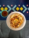 Flatlay picture of roti sarang burung on the table. It is pratha looks like bird nest with half cook eggs in the middle. With