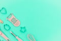 Flatlay pink kitchen utensils on neo mint background. Greater, whisk and iron cooking form. Top horizontal view copyspace love
