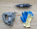 Flatlay repair tools on a wooden background. Toolbox with gloves, jigsaw and power saw.