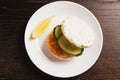 Flatlay, sandwich with salmon and cucumber and lemon on white plate