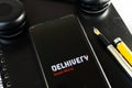 flatlay shot showing a mobile phone showing the delhivery app of indian logistics startup with pickup and delivery