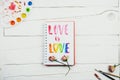 Flatlay of sketchbook with handlettering inscription `Love is love`