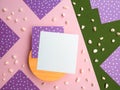 Flatlay square note sheets,wooden base,pink green paper, lilac of white polka dots on corners,pebbles.Design copy space