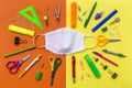 Flatlay with student accessories as ruler, pencil sharpener, scissors around medical face mask. Royalty Free Stock Photo