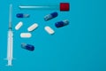 Flatlay, syringe, test tube and pills on a blue background with place for text