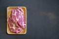 Flatlay Topview of Raw Pork is prepared for Cook, It is on wood plate on black granite kitchen counter tabletop, shot by studio
