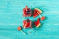 Two glass mugs with watermelon smoothie decorated with red Basil leaves. Watermelon slices on a blue wooden background. Top