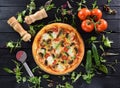 Flatlay of vegetarian pizza, fresh tomatoes, cucumbers, fresh he